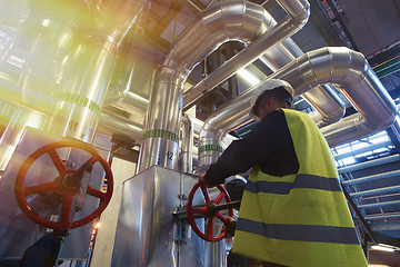 Image showing factory worker turning valve