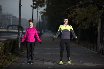 Image showing a young couple warming up before jogging