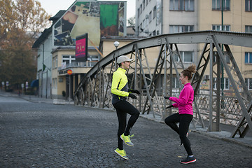 Image showing couple warming up before jogging