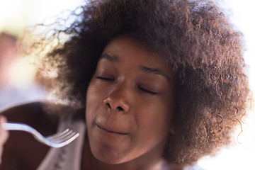 Image showing a young African American woman eating pasta