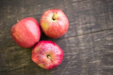 Image showing Three red apples on wooden table