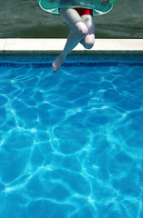 Image showing Young woman jumping in swimming pool