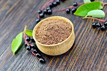 Image showing Flour bird cherry in bowl with berries on board