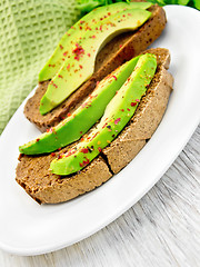 Image showing Sandwich with avocado and pepper in dish on board
