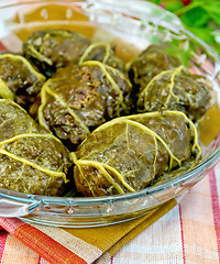 Image showing Rhubarb leaves stuffed in glass pan on towel