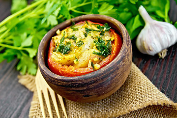 Image showing Fish baked with tomato in clay bowl on board