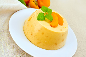 Image showing Panna cotta apricot with mint and napkin on table