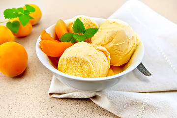 Image showing Ice cream apricot with mint in white bowl on napkin