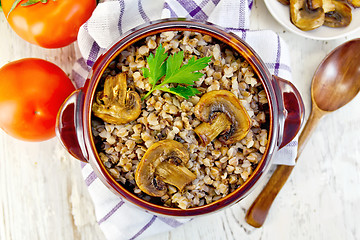 Image showing Buckwheat with mushrooms in clay bowl on towel top