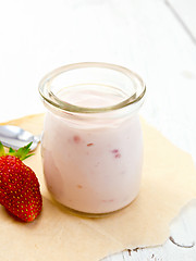 Image showing Yogurt with strawberries in jar on parchment