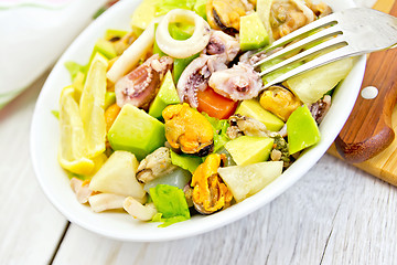 Image showing Salad with seafood and lemon in plate on white board