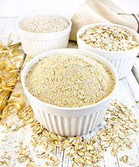 Image showing Flour oat in white bowls with bran and flakes on board