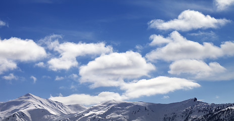 Image showing Panoramic view on sunlight snow mountains and blue sky with clou