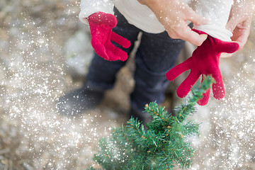 Image showing Mother Putting Red Mittens On Child with Snow Effect