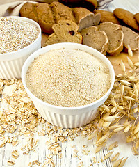 Image showing Flour oat and bran in white bowl with bread on board