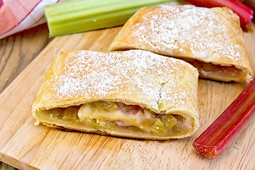 Image showing Strudel with rhubarb and napkin on wooden board