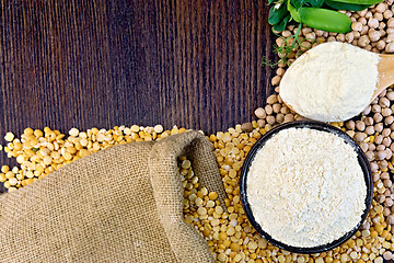 Image showing Flour pea in spoon and chickpeas in bowl on board