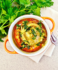 Image showing Fish baked with tomato in red pot on table top