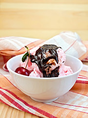 Image showing Ice cream cherry with chocolate syrup on board