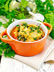 Image showing Fish baked with tomato in red pot on light board