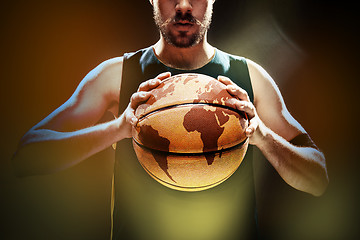 Image showing Silhouette view of a basketball player holding basket ball on black background