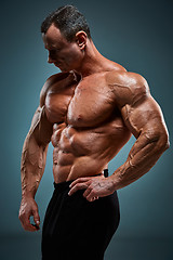 Image showing torso of attractive male body builder on gray background.
