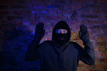 Image showing Surprised thief with hands up
