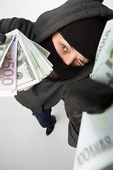 Image showing Burglar in gloves with money