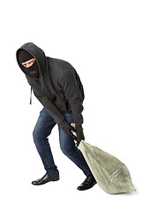 Image showing Thief in gloves drags bag