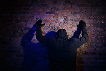 Image showing Gunman against wall at night