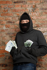 Image showing Robber in mask with banknotes