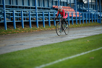 Image showing Athletic young woman riding bicycle on the road