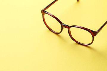 Image showing Brown glasses on yellow background