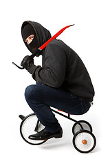 Image showing Robber going on children\'s bicycle