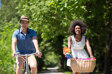 Image showing Young multiethnic couple having a bike ride in nature