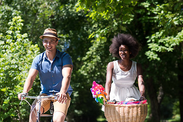 Image showing Young multiethnic couple having a bike ride in nature