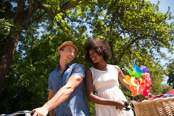 Image showing Young multiethnic couple having a bike ride in nature