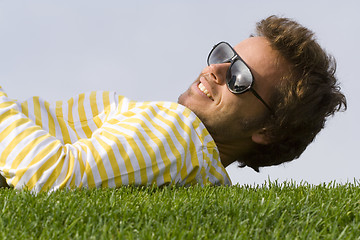 Image showing Young man lying down on the grass