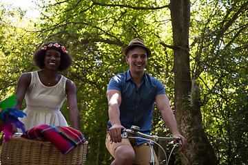 Image showing Young multiethnic couple having a bike ride in nature