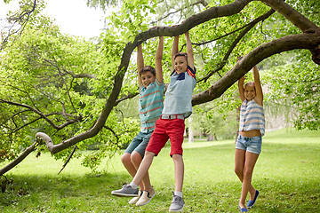 Image showing happy kids hanging on tree in summer park