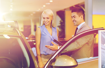 Image showing happy woman with car dealer in auto show or salon