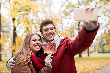 Image showing couple taking selfie by smartphone in autumn park