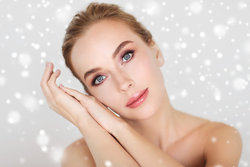 Image showing beautiful young woman face and hands over snow