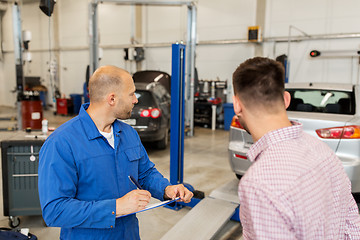 Image showing auto mechanic with clipboard and man at car shop