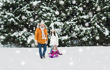 Image showing happy family with sled walking in winter forest