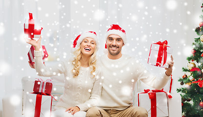 Image showing happy couple at home with christmas gift boxes