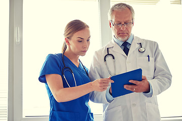 Image showing senior doctor and nurse with tablet pc at hospital