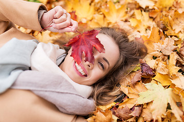 Image showing beautiful happy woman lying on autumn leaves