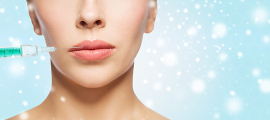 Image showing close up of woman face and syringe over snow