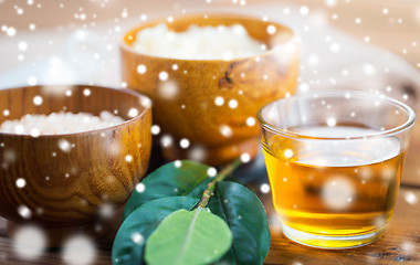 Image showing close up of honey in glass with leaves on wood